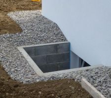 Bordure le long de la maison remplie avec des cailloux en granit