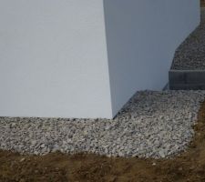 Bordure le long de la maison remplie avec des cailloux en granit