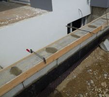 Mur de sortie de cave réhaussé d'une rangée de parpaing et prêt pour la chape