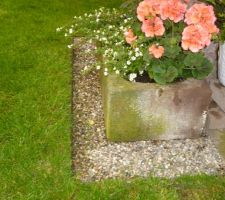 Arrêt de pelouse autour du bac à fleurs en grès des Vosges