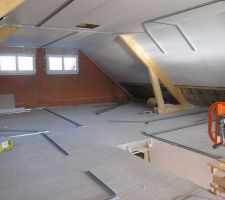 Au cours de la semaine du 21 au 25 mai 2012, le plaquiste a fixé les plaques de placo-plâtre dans les combles et a ainsi pu disposer au plafond la laine de verre (300 mm)et prévu la trappe de visite. Il lui reste la partie inférieure des rampants à couvrir de plaques de placo.
A l'étage, il a aussi commencé à disposer au sol et au plafond les rails des cloisons