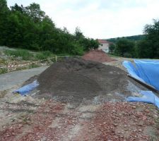 Mise en place des premières rangées d'agglos et des 20cm de laitier (soit environ 50 tonnes à descendre!!) sous la dalle béton de 10cm de la cave.
Il reste encore un peu de laitier sur le haut du terrain.