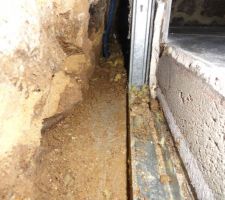 Vue de l?int&eacute;rieur du trou entre le mur de pierres et la dalle b&eacute;ton. Le fond du trou n'est pas constitu&eacute; de terre battue mais de b&eacute;ton.