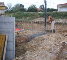 Le maçon aux commandes pour répartir le béton pour les fondations du garage.