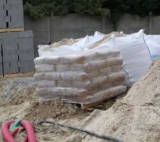 Arrivée matériaux sur le chantier: parpaings et sacs de ciments pour le sous-sol.