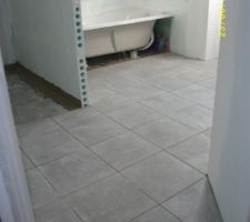 Carrelage en cours , gris clair dans la salle de bain .