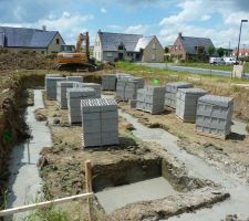 Vue d'ensemble du chantier : la semelle a &eacute;t&eacute; coul&eacute;e, les parpaings ont &eacute;t&eacute; livr&eacute;s sur site