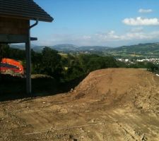 Terre végétale stockée en attendant la fin du chantier...Sous la butte, le terrassier a fait une plateforme arrondie sur laquelle nous mettrons une piscine Hors Sol. Elle sera au final semi enterrée grâce à la pente du terrain. (avec accès depuis la terrasse qu'on fera en angle et en bois sûrement du composite...)