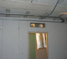 La bouche de soufflage au dessus de la porte de la salle d'eau parent