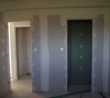 Vue de la chambre sur la porte qui mène au couloir et l'autre à la salle de bain