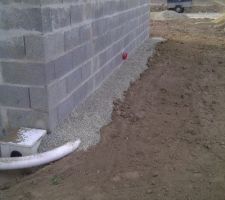Drain sur le coté de la maison, avec finition de gravier.