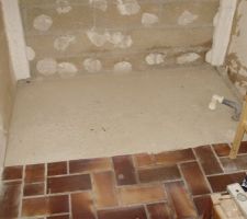 Emplacement d'environ 1m70 x 1m x 65mm pour le receveur à carreler.
Au fond, sur chaque côté, on peut voir ce qui subsiste du polystyrène que j'ai ramené de 80 à 60mm.
Sur la gauche, une cloison alvéolaire complète 10 30 10, sur laquelle j'hésite entre poser du BA13 hydro ou étanchéifier.
Sur la droite, la paroi placo 10mm qui subsiste de la cloison alvéolaire, dans laquelle j'envisage de monter 5 rangs de carreaux de plâtre hydro.
Au sol, la dalle qui se situe à 65mm sous le niveau du carrelage flammé. L'évacuation PVC à droite sera retirée, bien sûr.