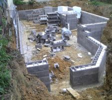 A gauche le mur de la maison voisine est long&eacute; par une paroi en parpaings &agrave; bancher. On voit que la cave en sous sol sous la totalit&eacute; de la maison est r&eacute;alis&eacute;e en blocs isolants.