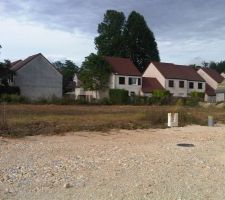 Passage sur le terrain, les maisons commencent &agrave; pousser dans le lotissement et le champ a &eacute;t&eacute; fauch&eacute;.