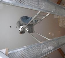 Pour installer la suspension au dessus du vide de la mezzanine, il fallait être acrobate et ne pas souffrir du vertige. Deux bastaings de grande longueur ont été posés au dessus du vide et sur les bastaings ont a mis un escabeau. "Il n'y avait plus qu'à" monter sur l'escabeau pour réaliser l'opération