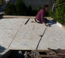 Pose des planches d'OSB sur les chevrons. L'OSB forme le nouveau plafond
