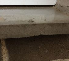 Seuil de fenêtre un peu cassé, et du béton a coulé sur le dessus (pas grattable)