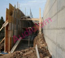 Photo de l'espace entre les deux murs. A droite, le 1er mur est déjà décoffré alors que celui de gauche est sur le point d'être coulé.