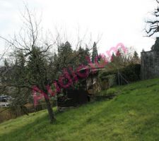 Une photo de l'état du jardin d'origine où on peut voir la pente du terrain et l'emplacement de la cabanne de jardin. Le terrain semble la pousser pour qu'elle tombe...