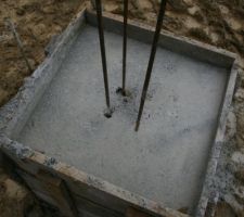 Une tête de pieux coulée avec les ferraillage en attente. Par contre pourquoi y a t'il des petits trous ? C'est normal que les ferraillages en attente soit plantés à la fin et enfoncés de seulement 5 à 10 cms?