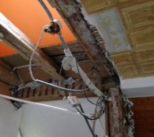 Le mur de séparation a fait apparaitre une poutre-poteau verticale avec renfort oblique qui vient soutenir une poutre horizontale le long de la facade mansardée et une autre poutre horizontale perpendiculaire qui elle passe par le milieu de l'appartement  ( des cables electriques longent cette poutre par le dessous) et cette poutre gene pour créer la tremie   possibilite de la couper  et de creer renfort pour remplacer cette poutre?