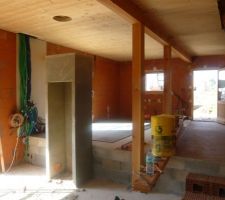 Vue vers la cuisine depuis le salon, au premier plan l'habillage du poele en b&eacute;ton : carrelage en cours