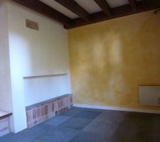 La cheminée à droite et derrière le mur, la cuisine