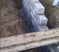 Gros plan sur une partie des fondations. On apercoit la semelle de beton au fond