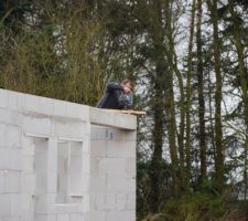Perçage et fixation réalisés dans la ceinture en béton armé du dernier rang de blocs
