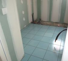 Le carrelage de la salle de bains des enfants est posé. Le carreleur attend que le plombier ait posé la baignoire pour faire la faïence