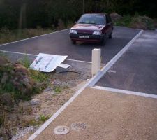 La , je suis en entrée de mon terrain , tourné vers la voirie , le panneau PC a terre , la voirire , le boitier EDF , le terrain est limité aux bordures de la voirie , ici ont voit bien que devant le terrain est en contre bas !! aie aie aie pour faire un mur en parpaings par la suite !
