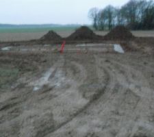 Chemin d'acc&egrave;s un peu ravag&eacute; par les engins de terrassement et les camions toupies. Apercu des fondations en second plan.