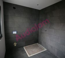 Salle de douche de la chambre d'amis terminée au niveau du carrelage. On distingue à gauche le mur de la fenêtre qui restera blanc.
