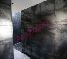 Un vue de la salle de douche parentale depuis la porte donnant dans le dressing, avec le carrelage terminée et la douche au fond