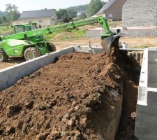 Enfin, le soleil daigne se montrer, le drainage &eacute;tant achev&eacute; on comble avec de la terre le contour de cave.
Il restera &agrave; installer la pompe de relevage et les puisards pour recueillir et &eacute;vacuer cette eau si n&eacute;cessaire.
