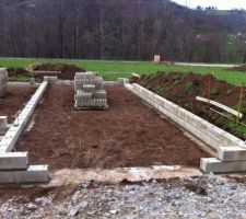 Deux mois (&agrave; quelques jours pr&egrave;s) que les fouilles ont &eacute;t&eacute; coul&eacute;es puis pluie pluie neige pluie pluie. lors d'un timide rayon de soleil le ma&ccedil;on &agrave; amen&eacute; tout le mat&eacute;riel pour attaquer il ne manquait plus que les hommes puis finalement rien. pluie pluie pluie &agrave; nouveau. on s'est un peu battu pour que le ma&ccedil;on revienne sur le terrain mais il avait d&eacute;but&eacute; d'autres chantiers ailleurs mais aujourd'hui c'est notre tour. la premi&egrave;re rang&eacute; de moellon est pos&eacute;e et m&ecirc;me la seconde par endroit. le plan en pr&eacute;voit trois au total pour sur&eacute;lever la maison l&eacute;g&egrave;rement au dessus du niveau de la route et permettre aux eaux de pluie de s'&eacute;vacuer non pas vers la maison mais vers la route.