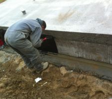 Pose de l'enduit bitumeux sur la face Est, on voit aussi la cunette.