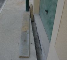 Preparation devant la porte du garage pour la pose du caniveau.L'eau se jetera dans le regard de descente d'eau de pluie à l'angle de la maison.