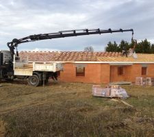 En cours de dépose des tuiles. Il travaille tout seul avec la télécommande du camion !