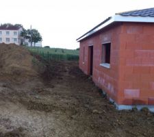 La façade Est/Sud-Est est enfin dégagée... du moins un peu. Nous sommes en train de voir si l'on peut décaisser sur 7 ou 8 mètres de plus pour mettre une terrasse et avoir un certain recul de la maison. On mettra ensuite un drain au pied du talus