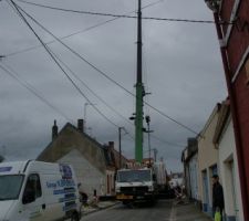 La grue passage des éléments au dessus des fils et de la maison voisine