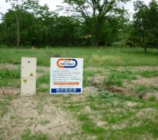 Le panneau du permis de construire posé sur le terrain.
