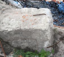 Des morceaux de ferrailles trouvées sur le chantier mis dans les trous des semelles isolées de nos poteaux à même la terre. Puis coulage des semelles malgré les alertes de notre expert. On détail sur cette photo une des semelles isolées que le constructeur a retiré du sol sur lequel apparaît nettement le ferraillage qui était en contact de la terre. À la longue comme explique mon expert la ferraille s'oxyde avec le contacter de la terre et de l'humidité se détériore créer des fissures dans la semelle ce qui la casse et fragilise celle-ci et ce qui provoquera dans le temps un déséquilibre des poteaux puis de la toiture...