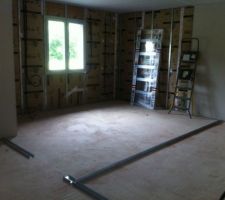 La chambre 1 13.18m² 
on voit appuyée contre le mur le rail de la future porte coulissante encastrée dans le mur