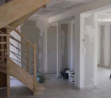 Vue du salon vers entrée à gauche et cuisine à droite