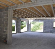 Vue, depuis l'entrée, de la pièce de vie : salon au premier plan (derrière le mur de refend à gauche) et salle à manger au fond à l'angle. La fenêtre panoramique à droite est celle de la cuisine qui sera fermée par une porte à galandage.