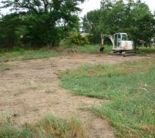 Décapage de la terre en surface pour délimiter l'emplacement de la maison.