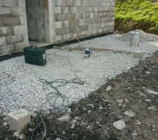 Préparation sous la future dalle de l'abri. A droite de la porte d'entrée, le regard pour le robinet d'eau extérieur.