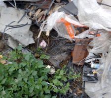 Les charpentiers comme les couvreurs ont balanc&eacute; leur d&eacute;chets sur le terrain. ils ont recouvert le compteur et le tuyau d'eau alors qu'ils avaient une poubelle a  disposition.