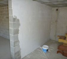 Une couche d'enduire afin de lisser les parpaings et avoir une certaine uniformité avec les murs en béton